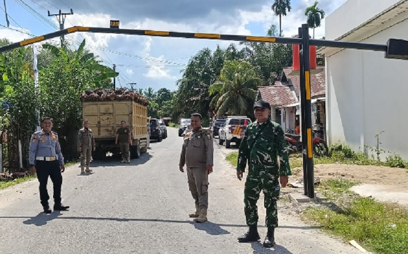 Personel Dinas Perhubungan dan Satpol PP Kuansing meninjau portal ruas jalan Desa Teratak Air Hitam yang bengkok Dihajar truk sawit, Rabu (15/10/2025).