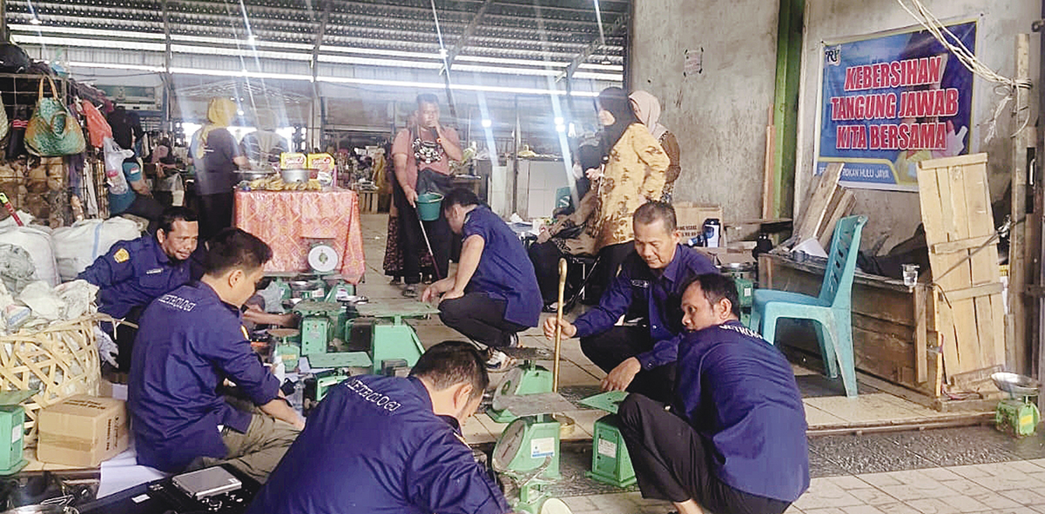 TERA ULANG: Tim Metrologi Disperindag Rohul melakukan tera ulang timbangan pedagang di Pasar Modern Pasirpengaraian secara gratis, Kamis (16/10/2025).