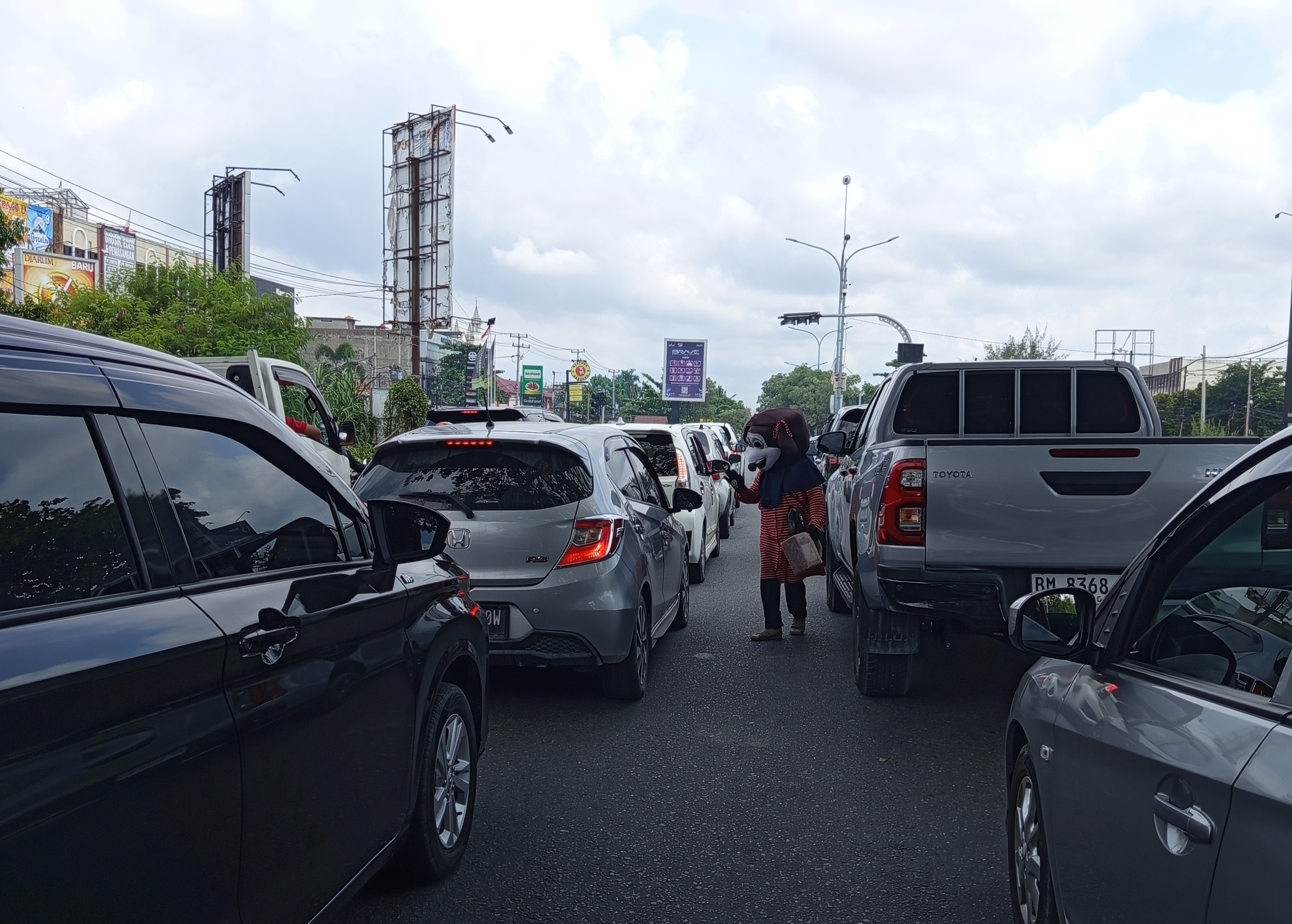 Seorang Badut saat meminta di kawasan persimpangan Jalan Soekarno-Hatta, Pekanbaru, Jumat (17/10/2025) ft: MHD AKHWAN/RIAUPOS