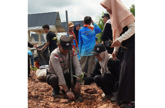 Mahasiswa IAIN Datuk Laksemana bersama personel Polsek Bantan menanam pohon di Pantai Selat Baru, Bengkalis, Jumat (17/10/2025).