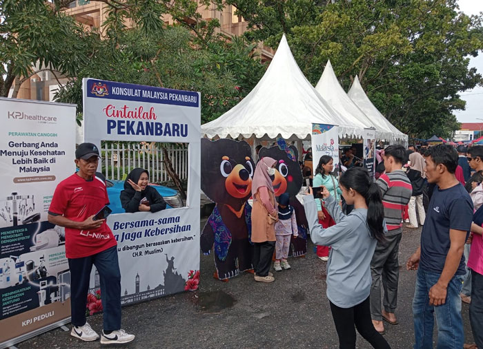 Pengunjung terlihat berfoto di beberapa icon khas Malaysia yang diperkenalkan oleh Konsulat Malaysia di Kawasan CFD Pekanbaru, Ahad (19/101/2025).