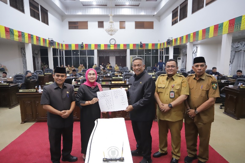 Bupati Rohul Anton ST MM bersama Ketua DPRD Rohul Hj Sumiartini menunjukkan berita acara persetujuan Ranperda RPJMD 2025-2029 yang telah ditandatangani dalam rapat paripurna di Gedung DPRD Rohul.