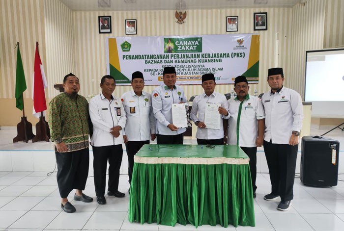 Kakan Kemenag Kuansing H Suhelmon MA CQEM bersama Ketua Baznas Kuansing Syafriadi SHI MH dan jajaran menunjukan nota MoU usai penandatangan, Senin (20/10/2025) di aula Kemenag Kuansing.