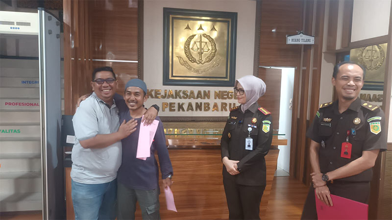Kajari Pekanbaru Silpia Rosalina didampingi Maruli Sitanggang menyaksikan dua mantan tersangka berangkulan usai bebas setelah menerima SKP2 berkat RJ, Selasa (21/10/2025).