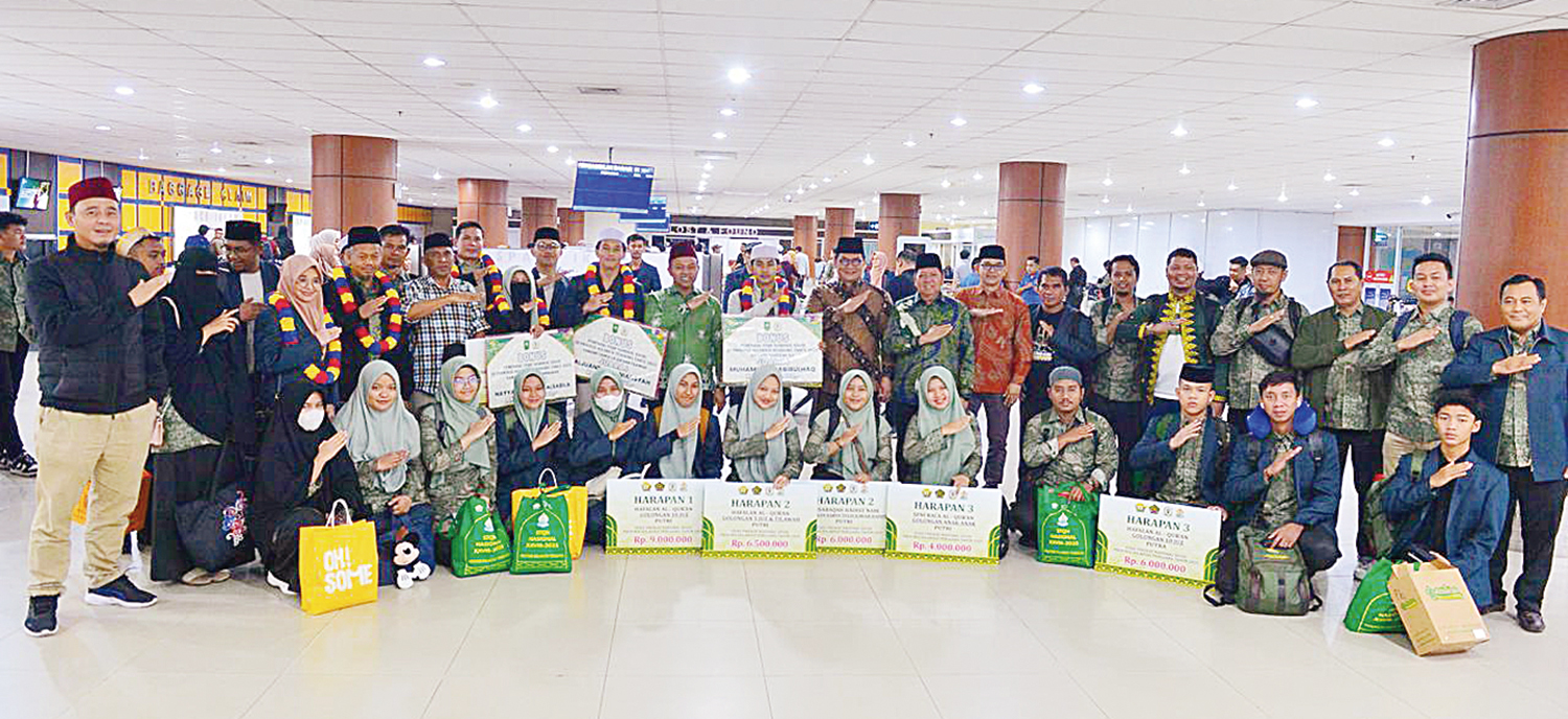FOTO BERSAMA: Para pemenang STQH Nasional foto bersama Gubernur Riau Abdul Wahid di Bandara SSK II Pekanbaru, Ahad (19/10/2025).