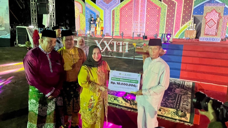 Bupati Bengkalis Kasmarni didampingi Ketua Baznas Ismail menyerahkan bantuan kemanusian korban kebakaran rumah di Rupat Utara, Bengkalis, Selasa (21/10/2025).