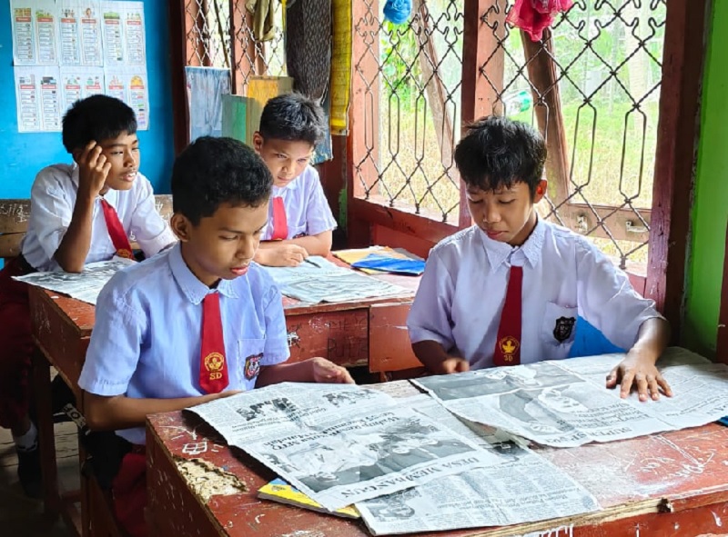 Murid SDN 007 Tanjung Raja, Kecamatan Kateman, Kabupaten Indragiri Hilir (Inhil) sedang belajar melalui media koran sebagai alat pendukung, Selasa (21/10/2025).