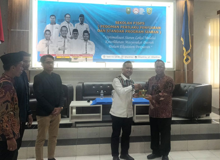 Ketua KPID Riau Bambang Suwarno menyerahkan plakat kepada Wakil Rektor III UIR Dedi Purnomo Retno, Rabu (22/10/2025).