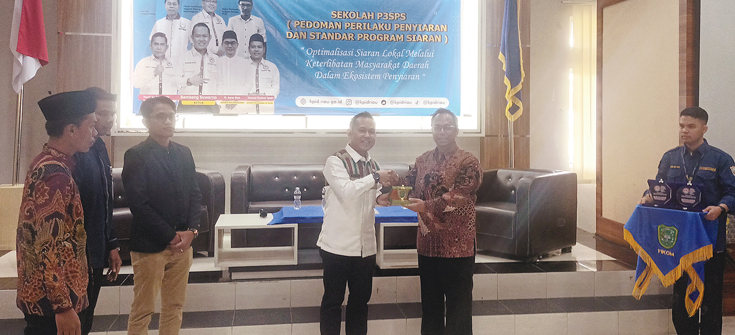 SERAHKAN PLAKAT: Ketua KPID Riau Bambang Suwarno (dua kanan) menyerahkan plakat kepada Wakil Rektor III UIR Dedi Purnomo Retno, Rabu (22/10/2025).