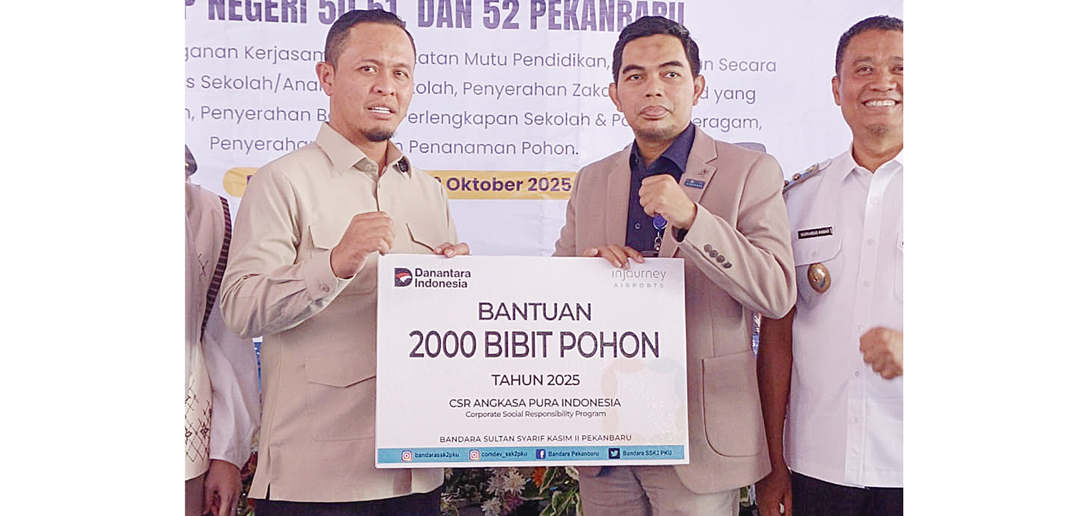 SERAHKAN BANTUAN:  General Manager Kantor Cabang Bandara Internasional Sultan Syarif Kasim II Achmad menyalurkan program bantuan CSR kepada Pemko Pekanbaru yang secara simbolis diterima Wali Kota Pekanbaru Agung Nugroho di sela peresmian Gedung Baru SMP N