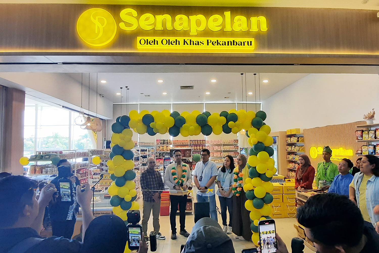 Komisaris sekaligus owner Senapelan Oleh-Oleh Pekanbaru Hengky Kurniawan (dua kiri) melakukan gunting pita saat melakukan grand opening di lt.1 Bandara SSQ II Pekanbaru, Ahad (26/10/2025).