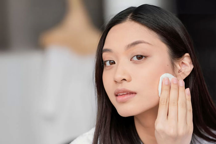 Ilustrasi perempuan membersihkan sisa kosmetik.