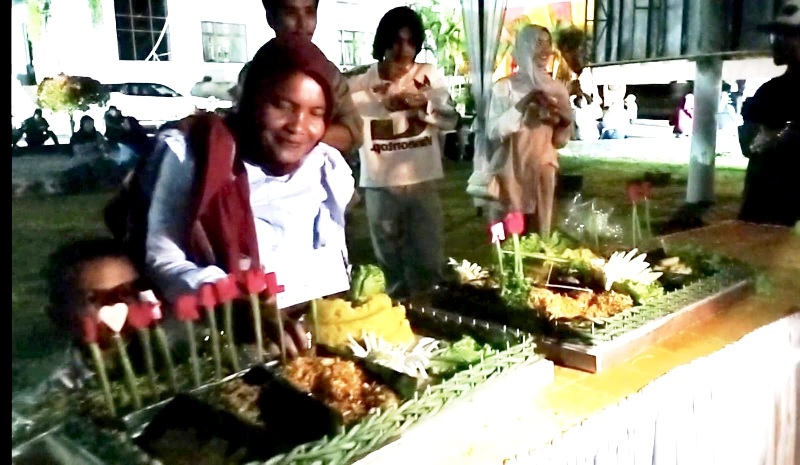 Sejumlah warga mengambil langsung nasi tumpeng gratis dari partisipasi perusahaan dalam acara pesta Rakyat Puncak HUT ke 26 di Kantor Bupati Rohul, Sabtu (25/10/2025) malam.