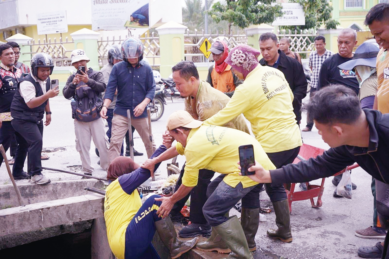 Wali Kota Pekanbaru Agung Nugroho membantu petugas kebersihan naik dari parit saat meninjau lokasi beberapa drainase di Pekanbaru, pekan lalu.