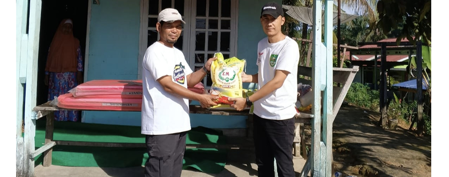 Plt Kadissos P3A Rohul April Liyadi (kanan) menyerahkan bantuan paskakebakaran berupa bahan pangan kepada korban Syukri di Dusun Pematang Baih, Desa Pematang Berangan, Kecamatan Rambah, Ahad (26/10/2025).