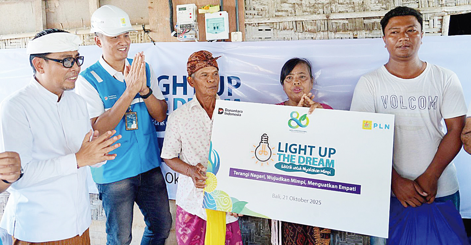 Senyum bahagia terpancar dari I Nyoman Nuki (tengah) dan Made Rasmi (kedua dari kanan), pasangan suami istri penerima manfaat bantuan penyambungan listrik gratis PLN. Penyerahan simbolis dilakukan GM PLN UID Bali Eric Rossi Priyo Nugroho (kedua kiri) dan