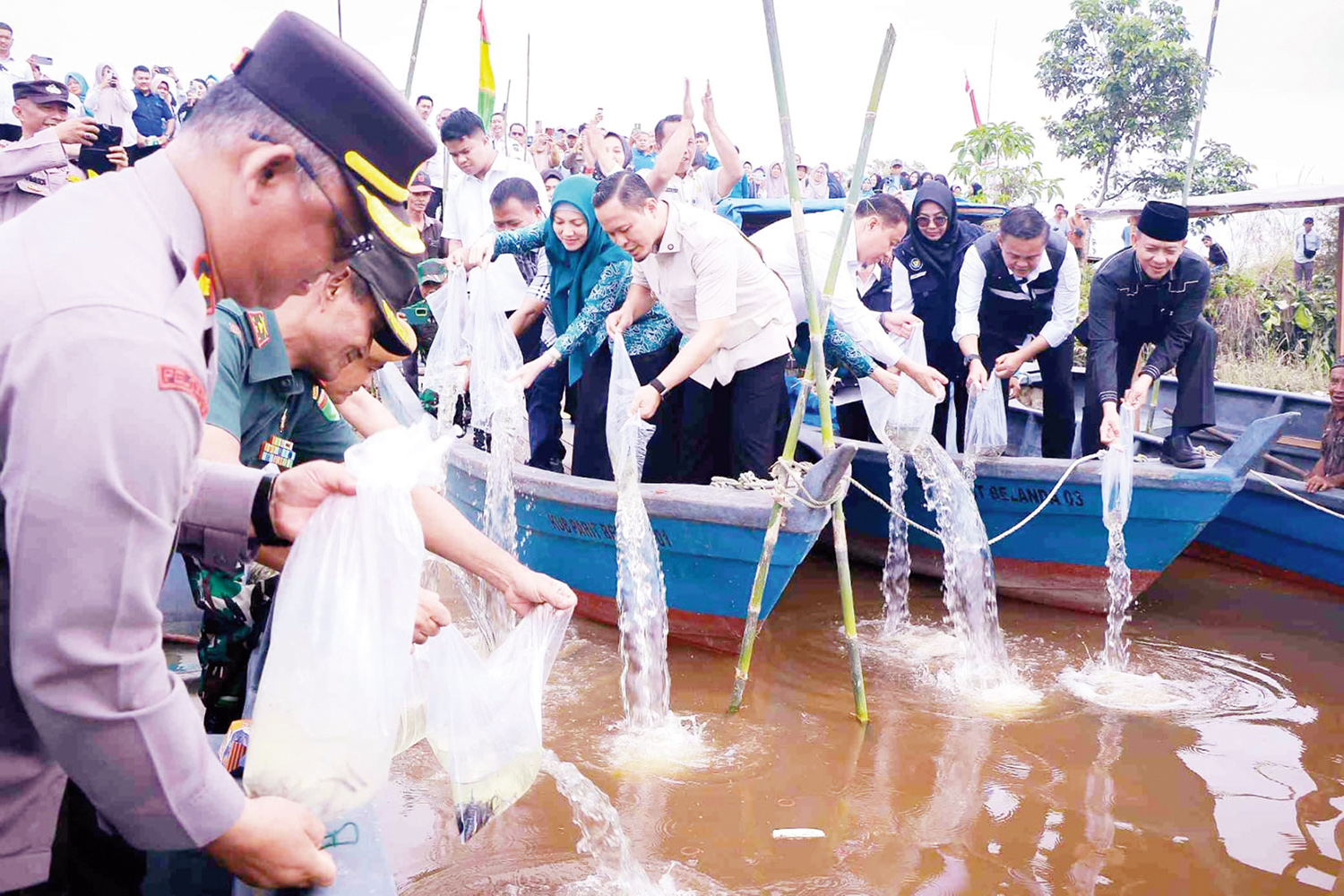 Wali Kota Pekanbaru Agung Nugroho didampingi Wakil Wali Kota Pekanbaru Markarius Anwar, Ketua TP PKK Pekanbaru Sulastri Agung, dan unsur Forkopimda Pekanbaru melepaskan bibit ikan saat peluncuran Program AMAN Bertani di Pelabuhan Harap Panjang, Jalan Telu