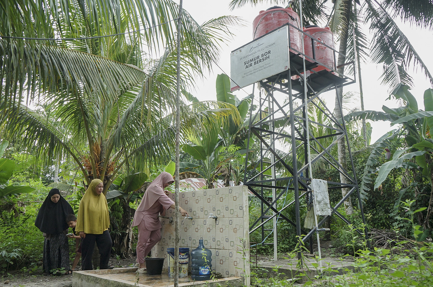 Sejumlah warga memanfaatkan air bersih bantuan Pertamina Hulu Rokan, Jumat (3/10/2025). Sebelumnya mendapat bantuan air bersih, warga bisa mendapatkan air dengan membeli air atau mencari kesumber air didalam hutan.
