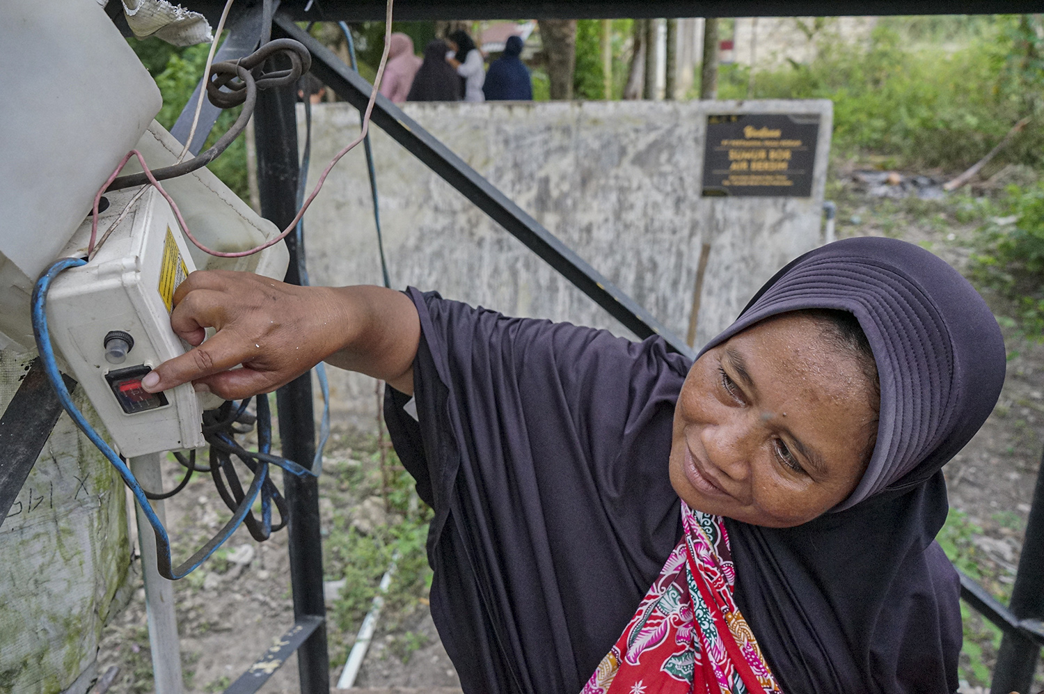 Seorang warga Sunarti mengontrol distribusi air bersih dari sumur ke rumah-rumah warga, Jumat (3/10/2025). Sebanyak 30 Kepala Keluara (KK) merasakan manfaat bantuan sumur bor air bersih bantuan Pertamina Hulu Rokan.