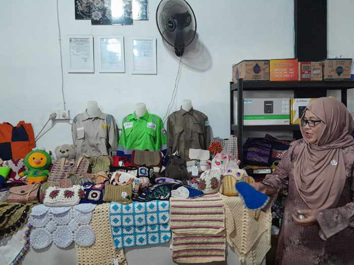 Pendiri KUB Rumah Jahit Lestari Suci Sustari memperlihatkan produk-produk kerajinan dari bahan limbah di gerai RJL Jalan Hangtuah, Duri, Rabu (24/9/2025).