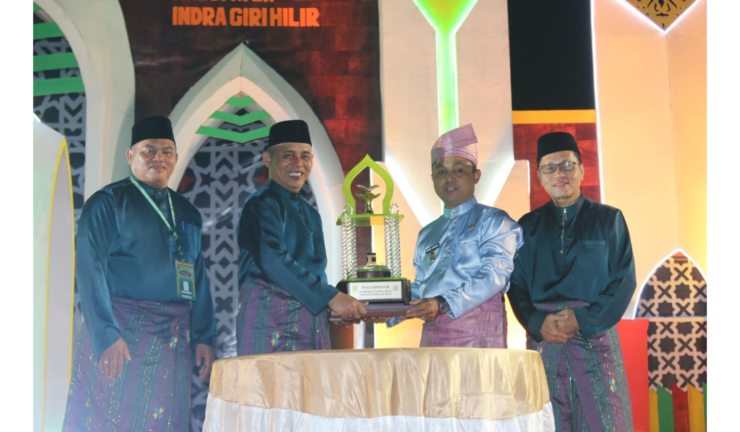 Bupati Inhil Herman menyerahkan penghargaan kepada salah satu pemenang MTQ tingkat Provinsi Riau di saat pembukaan MTQ ke-55 Inhil di Kecamatan Kempas, Rabu (29/10/2025) malam.&nbsp;