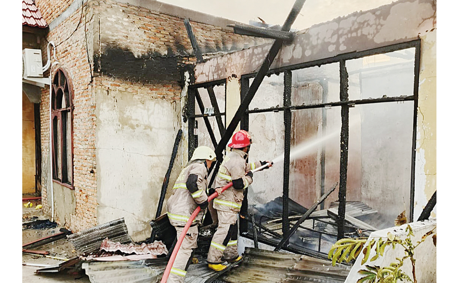 Petugas Pemadam Kebakaran Pekanbaru melakukan pendinginan usai memadamkan api yang membakar bangunan rumah warga di Jalan Cendrawasih, Gang Kakak Tua 2, Kelurahan Tangkerang Tengah, Kecamatan Marpoyan Damai, Rabu (29/10/2025).