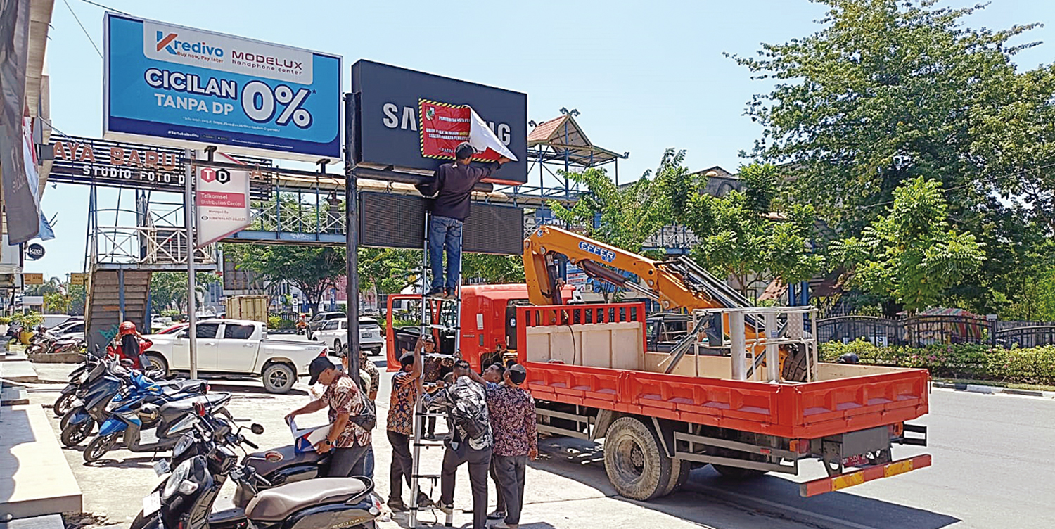 Petugas Bapenda Pekanbaru menyegel objek pajak reklame di Jalan Jenderal Sudirman, Pekanbaru, Kamis (30/10/2025).