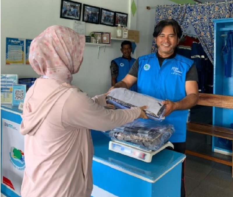 Risman tampak tengah melayani pelanggan Betuah Laundry dengan ramah.