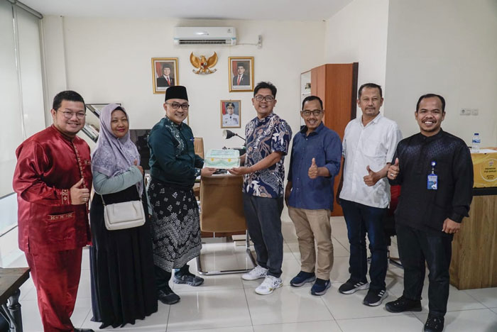 Dirut Riau Pos Ahmad Dardiri (Empat Kanan) serahkan kue tar yang diterima langsung oleh Dirut Jamkrida Riau Hafid Akbar dalam rangka HUT Ke-22 Jamkrida Riau.