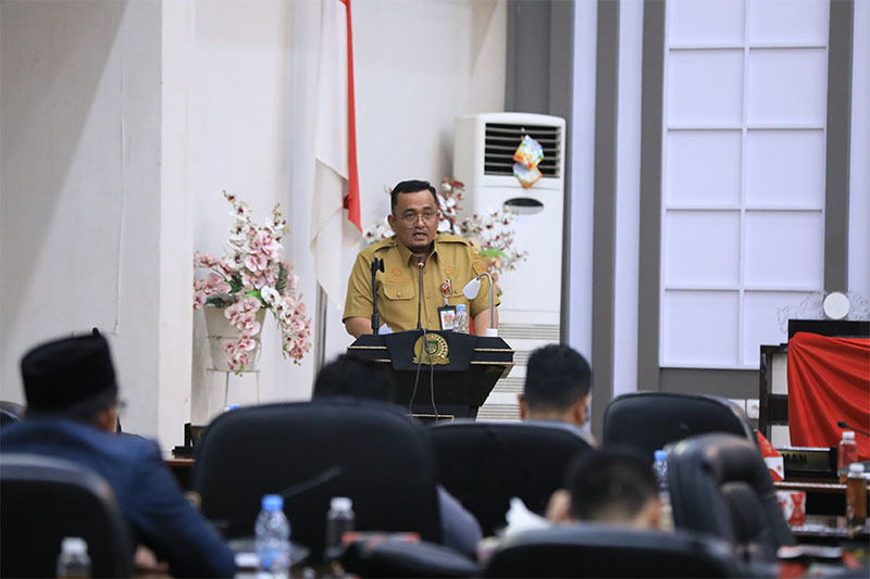 Sekda Muhammad Zaki membacakan jawaban pemerintah terhadap pemandangan umum fraksi DPRD dalam rapat paripurna di Gedung DPRD Rohul, Selasa (4/11/2025).