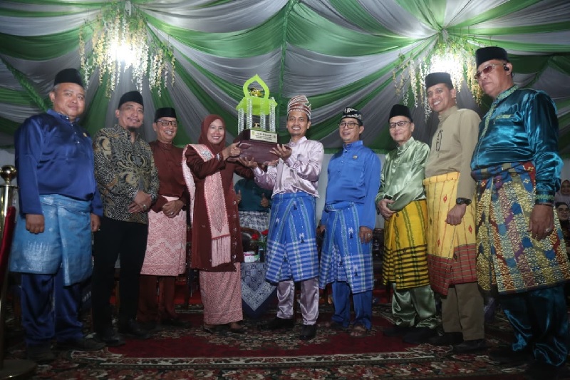 Wakil Bupati Inhil Hj Yuliantini menyerahkan piala ke pemenang pada pelaksanaan MTQ ke-55 Inhil di Kecamatan Kempas, Senin (3/11/2025).