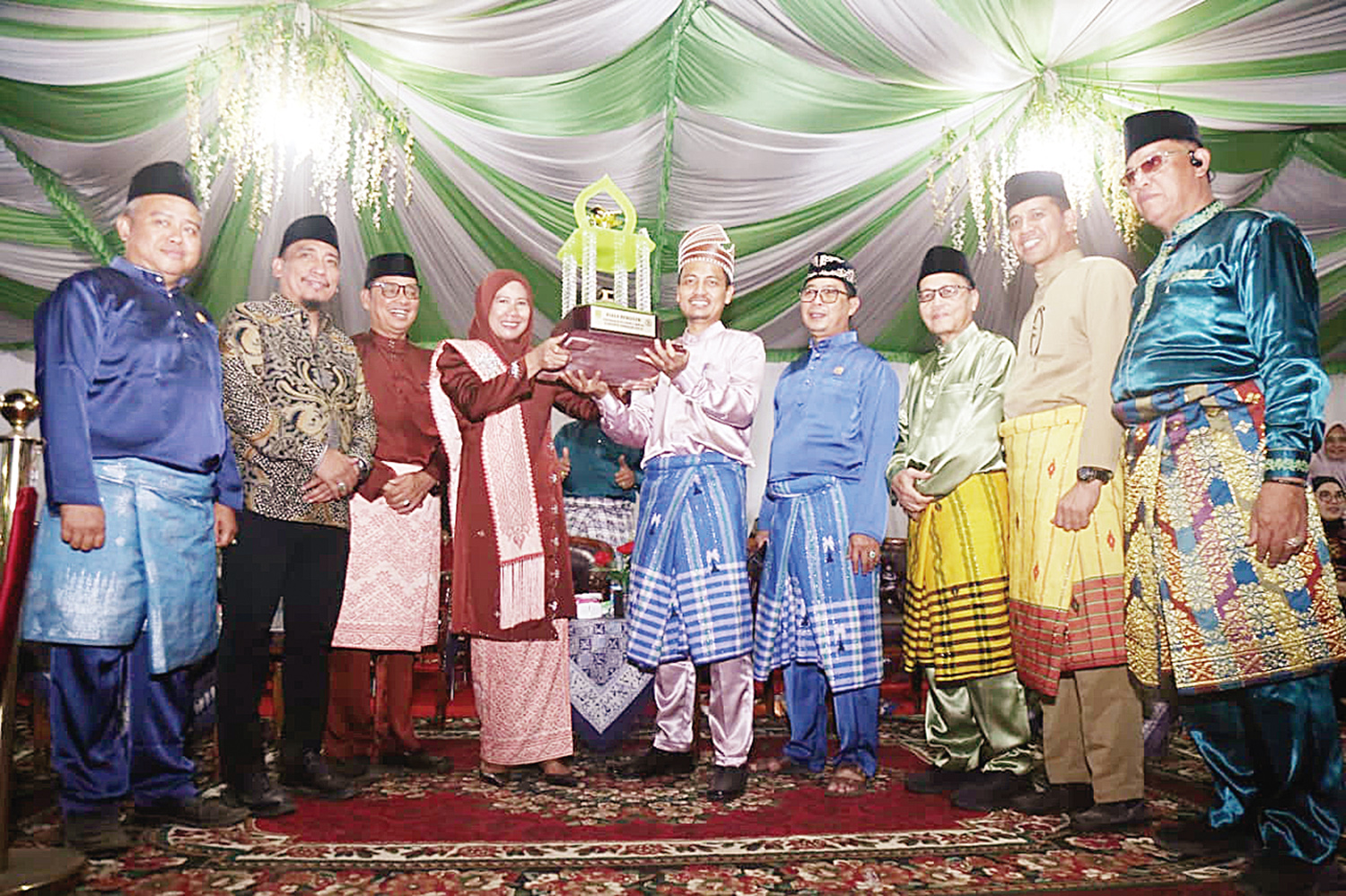 Wakil Bupati Inhil Hj Yuliantini menyerahkan piala ke pemenang pada pelaksanaan MTQ ke-55 Inhil di Kecamatan Kempas, Senin (3/11/2025) malam.