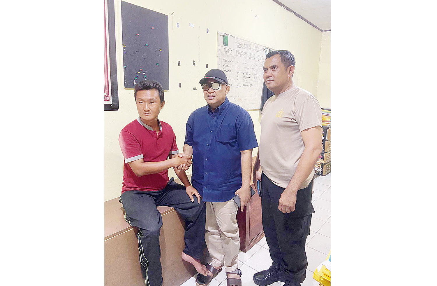 Ketua Komisi II DPRD Kabupaten Kampar Toni Hidayat (tengah) menyalami pelaku penyiraman air cabai Joko (kiri) disaksikan&nbsp;Kapolsek Siak Hulu Kompol Hendra Setiawan (kanan) di Mapolsek Siak Hulu, Senin (3/11/2025).