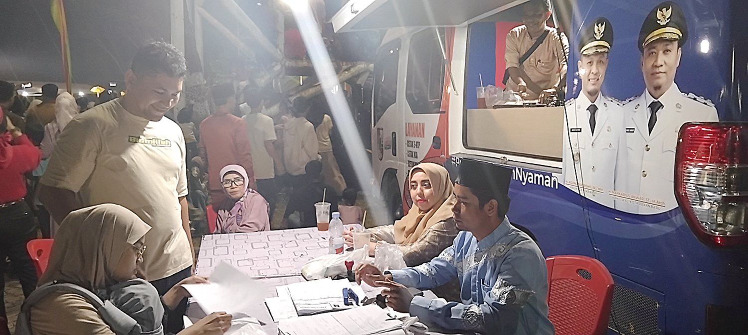 Petugas Disdukcapil Pekanbaru melayani masyarakat yang ingin mengurus administrasi kependudukan di lokasi MTQ Pekanbaru, Selasa (4/11/2025) malam.