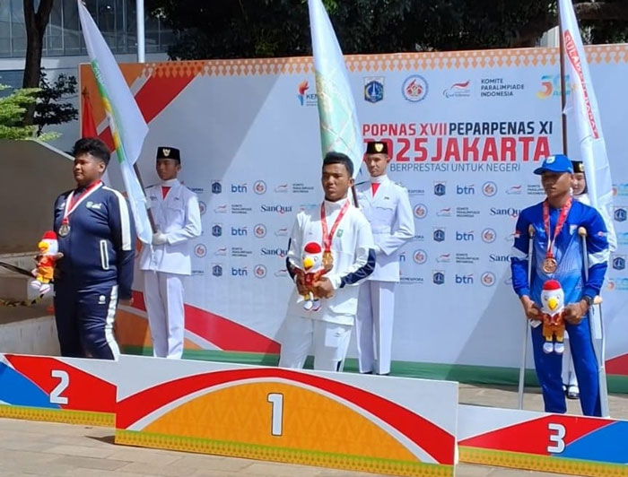 Atlet Riau Randy Kurniawan (tengah) foto bersama peraih medali tolak peluru putra F44 lainnya di GOR Atletik Ragunan Jakarta, Jumat (7/11/2025).