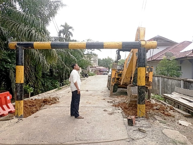 Petugas Dinas PUPR Rohul menggunakan alat berat saat memasang portal pembatas setinggi 2,3 meter di Jembatan Gantung Lubuk Bendahara, Kecamatan Rokan IV Koto, Jumat (7/11/2025) petang.