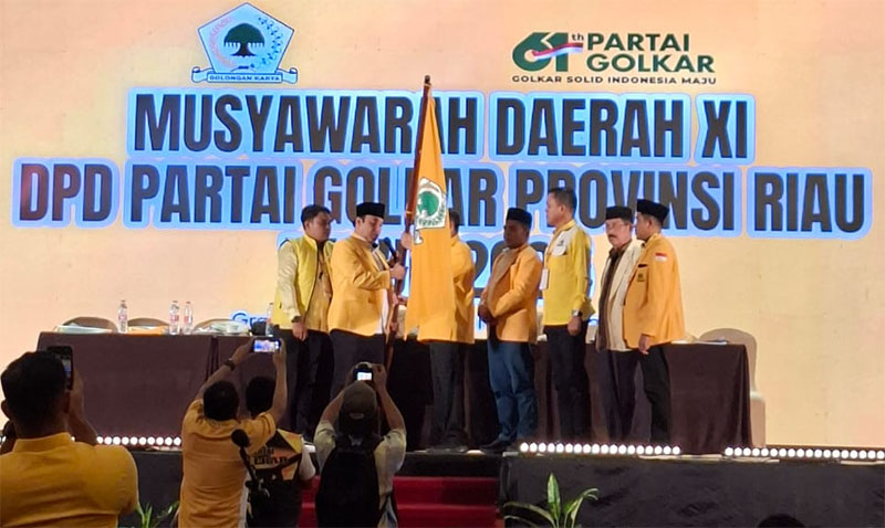 Yulisman menerima panji-panji Partai Golkar dari pimpinan sidang untuk dikibarkan se-Riau.