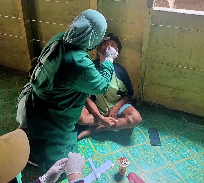 Tim kesehatan saat pengambilan dan pemeriksaan spesimen terhadap salah seorang warga Dusun Datai Desa Rantau Langsat, baru-baru ini.