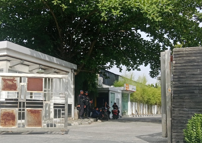 Petugas dari kepolisian berjaga di pintu gerbang depan kantor Dinas PUPR PKPP Riau, Selasa (11/11/2025).