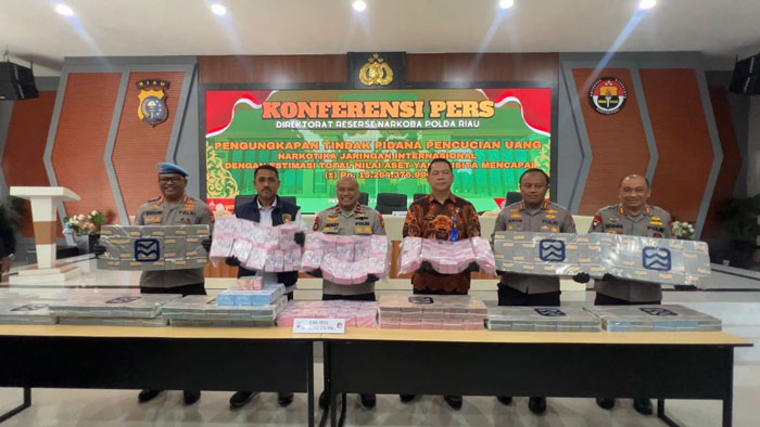 Wakapolda Riau Brigjen Pol Jossy Kusumo (tengah) bersama Dirnarkoba Kombes Pol Putu Yudha, Kabid Humas Kombes Anom dan pejabat lain memperlihatkan uang belasan miliar diduga hasil penjualan narkoba