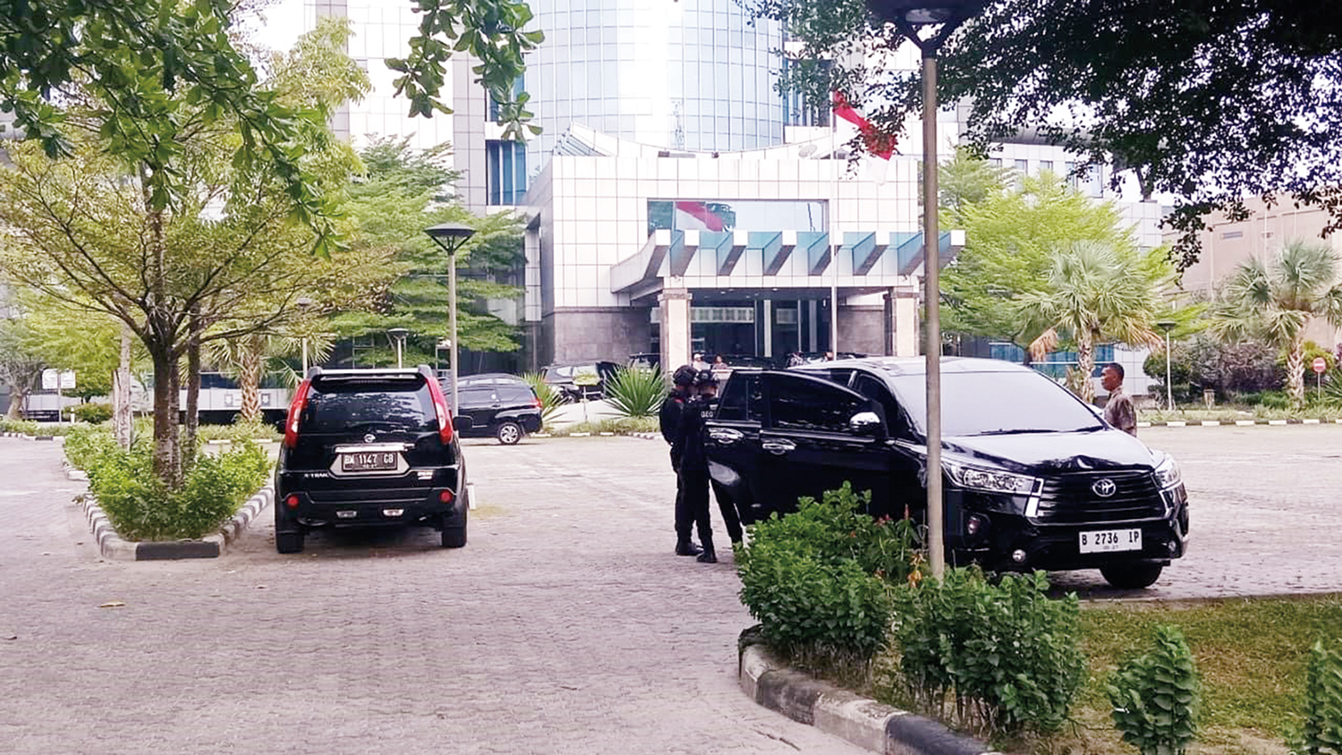 Petugas kepolisian dari Satuan Brimob Polda Riau tampak berjaga di area luar Kantor Dinas Pekerjaan Umum Penataan Ruang dan Perumahan Kawasan Permukiman Pertanahan Riau di Jalan SM Amin saat penyidik melakukan penggeledahan, Selasa (11/11/2025).
