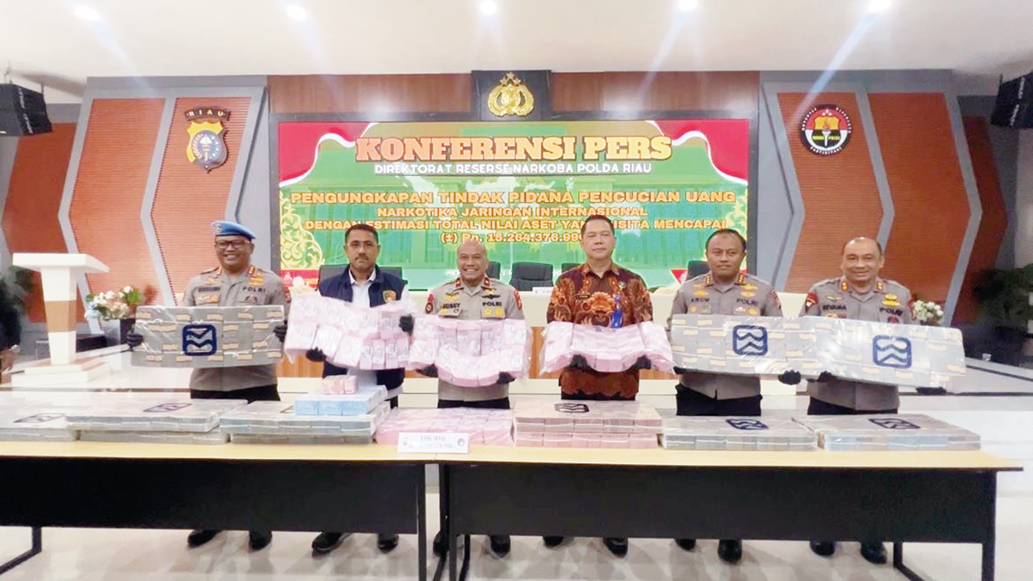 Wakapolda Riau Brigjen Pol Jossy Kusumo (tiga kiri) bersama Dirnarkoba Polda Riau Kombes Pol Putu Yudha, Kabid Humas Kombes Anom Karibianto, dan pejabat lainnya memperlihatkan uang tunai belasan miliar diduga hasil penjualan narkoba, Selasa (11/11/2025).