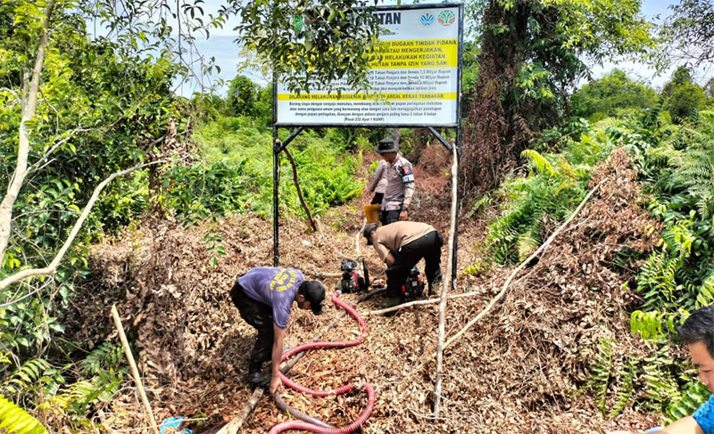 Kasat Reskrim Polres Kampar AKP Gian Wiadma Jonimandala memimpin pemasangan pamflet peringatan larangan pembakaran lahan di Desa Rimbo Panjang, Rabu (12/11/2025).