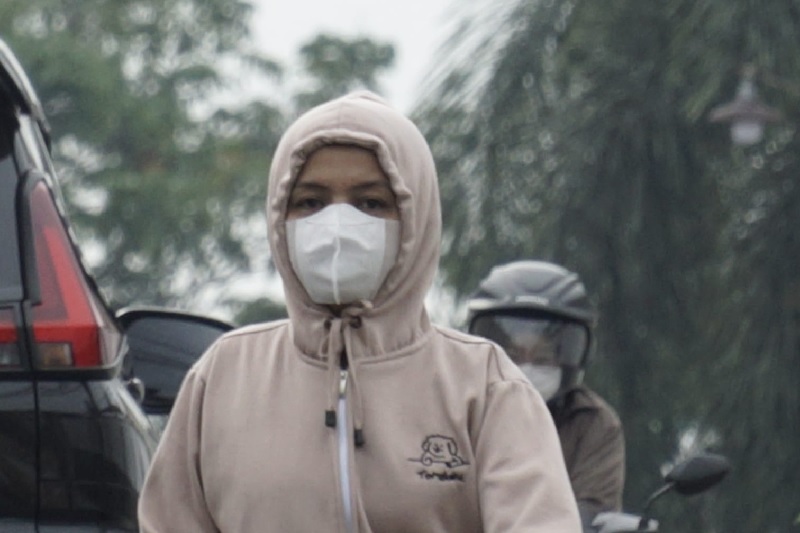Warga mulai memakai masker ketika berada di luar ketika kabut asap tipis menyelimuti Kota Pekanbaru pada Rabu (12/11/2025) pagi.