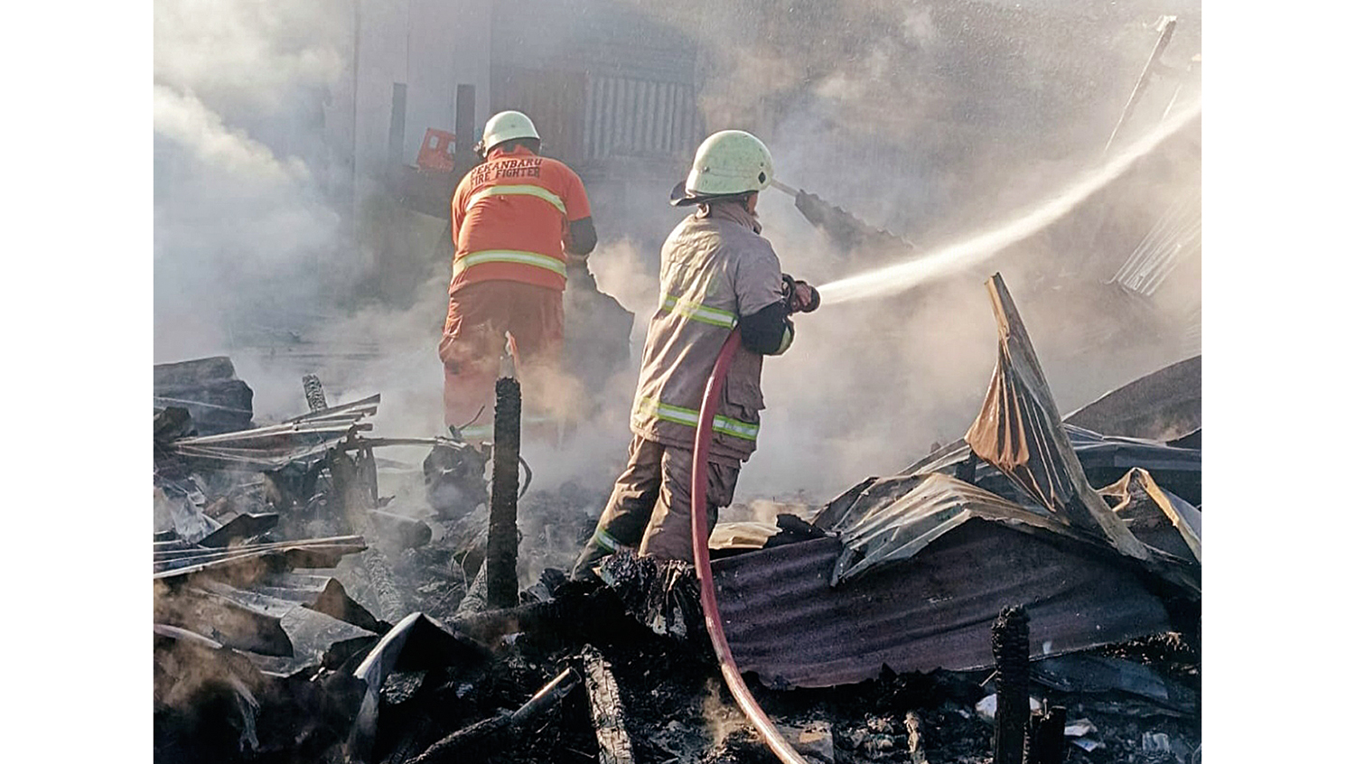 Pemadam Kebakaran berjibaku melakukan pemadaman api yang membakar tujuh kios di  Jalan SM Amin, RT 03/RW 06, Kelurahan Bandar Raya, Kecamatan Payung Sekaki, Pekanbaru, Kamis (13/11/2025).