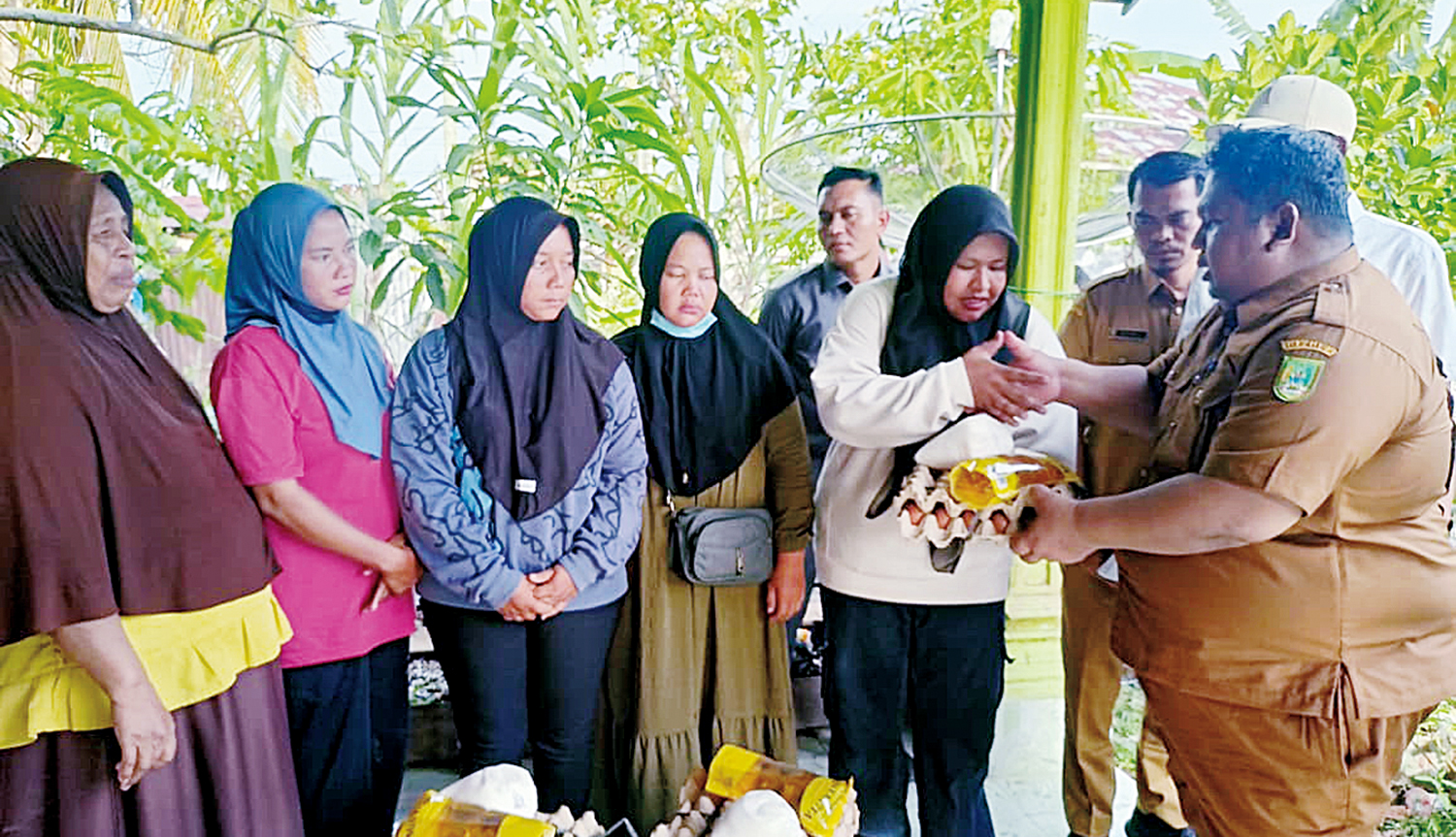 Kepala Diskan Rohil M Amin menyerahkan bantuan pangan untuk keluarga nelayan yang ditahan otoritas Malaysia di Bagansiapiapi, baru-baru ini.&nbsp;