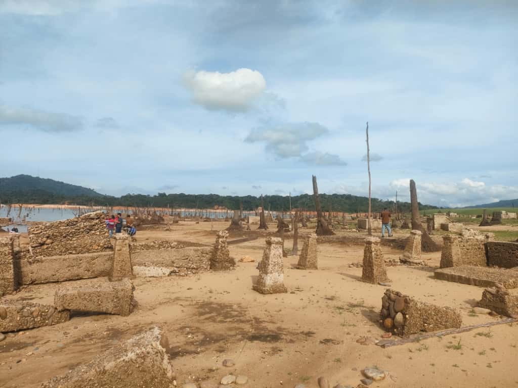 Tiang pondasi batu bekas rumah warga Desa Tanjung Alai yang tenggelam muncul kembali karena elevasi air waduk PLTA Kota Panjang yang terus menyusut, Rabu (12/11/2025).