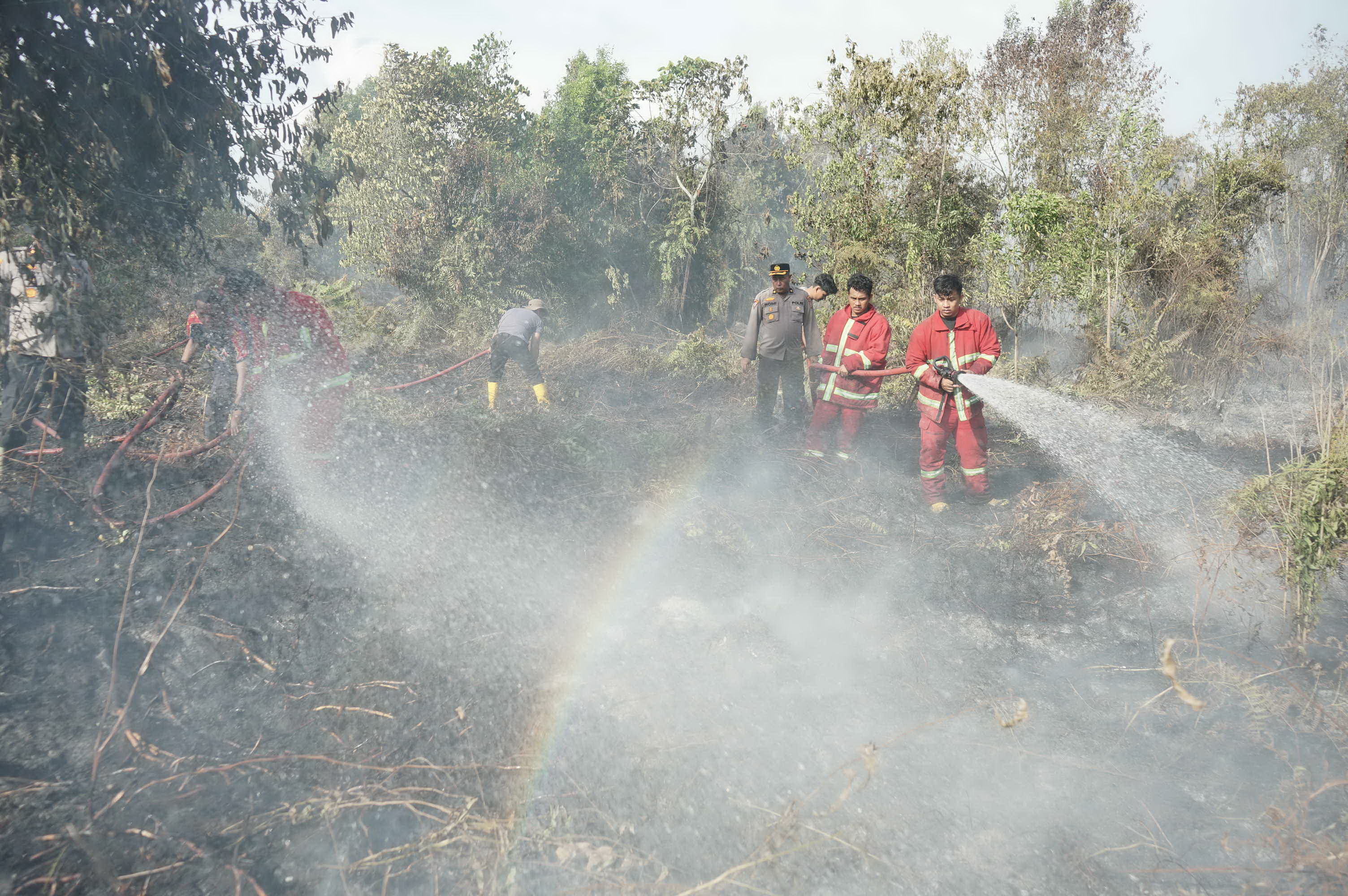 Petugas gabungan melakukan pendinginan lahan yang terbakar di Jalan Yuzura Desa Rimbo Panjang Kec Tambang Kab Kampar Provinsi Riau, Beberapa waktu lalu.