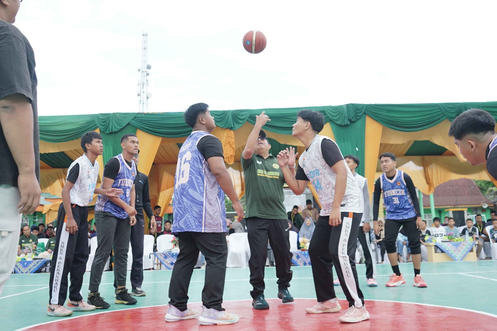 Ketua Yayasan Nur Iman Pekanbaru H Amrasul Abdullah ST MM melakukan jump Ball sebelum pertandingan pembuka DEHA Cup 2025 Basket Ball Competition di Ponpes Dar El Hikmah Pekanbaru, Ahad (16/11/2025).