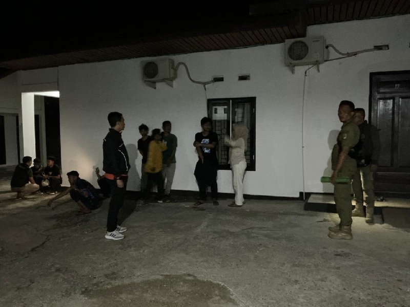Satpol PP-PKP Kuansing, menggiring sejumlah pasangan muda mudi yang belum menikah saat razia pekat, Sabtu (15/11/2025) malam di wilayah kecamatan Kuantan Tengah.